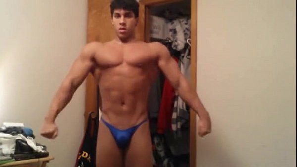 Young bodybuilder flexes his muscles in blue thong - 1